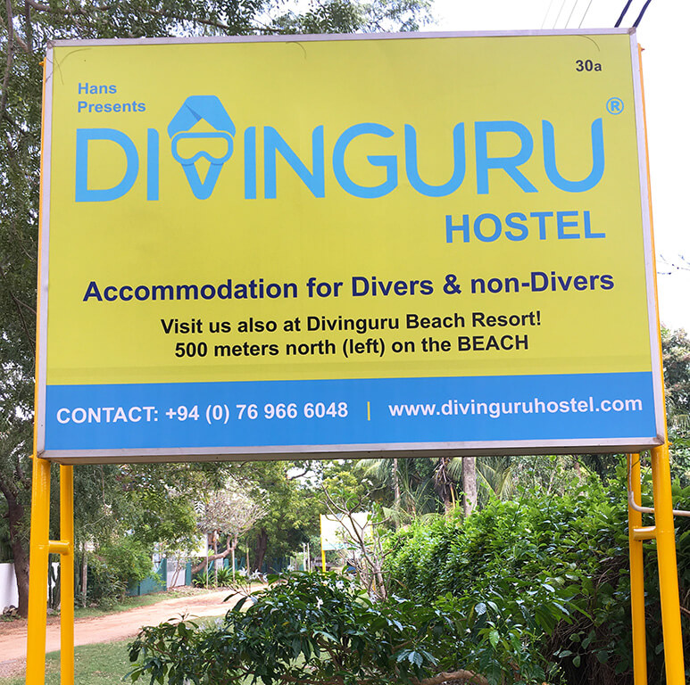 Divinguru Hostel welcome board on the road in Nilaveli